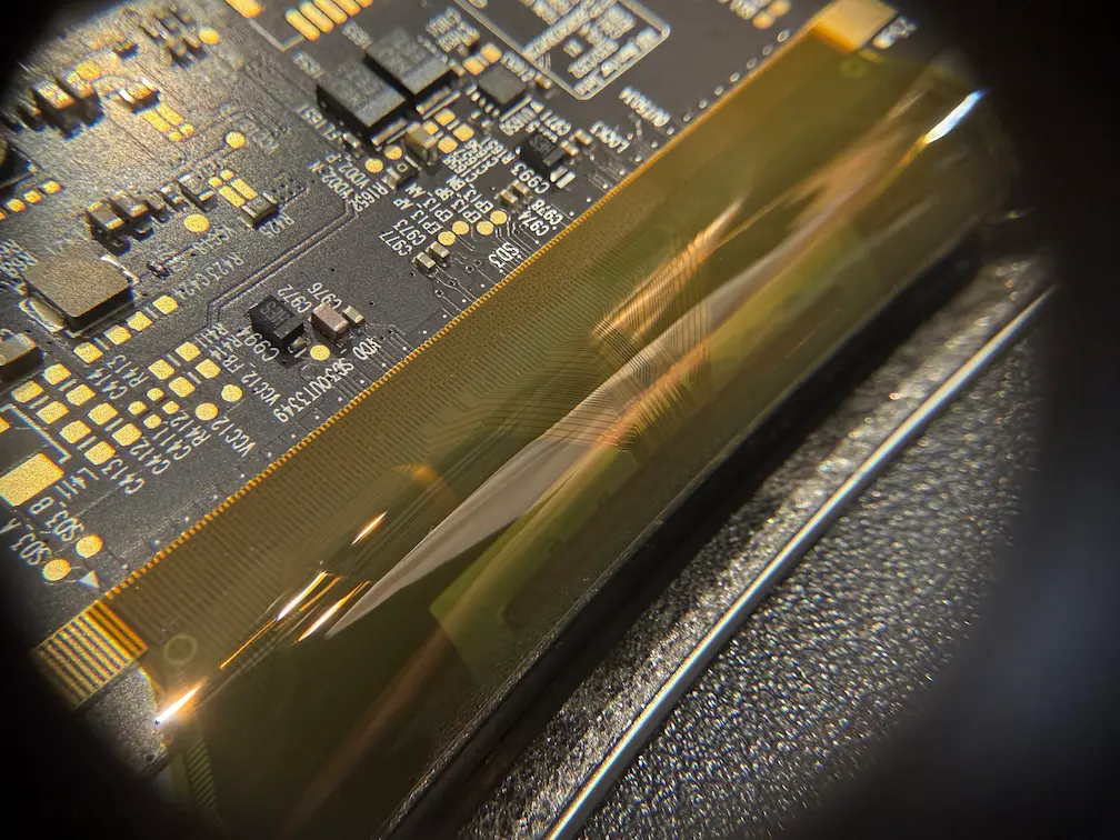 iMac M1 螢幕軟排線（Flex Cable）微距細節：展示高壓電路區的排線接點與導電材料結構