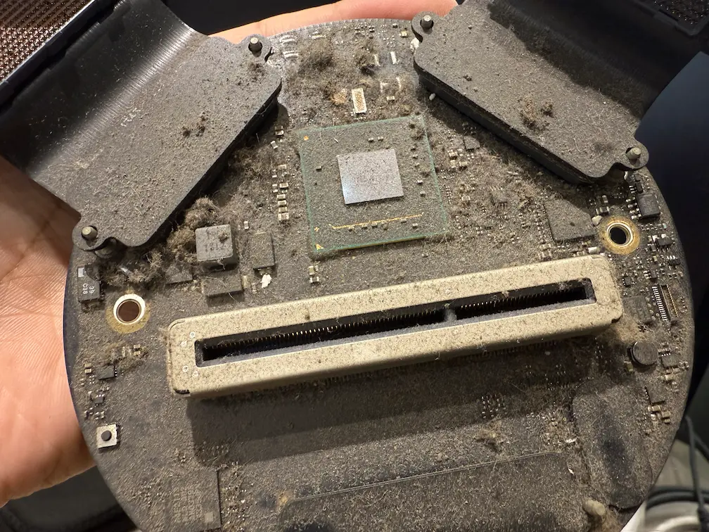 MacBook 內部積塵嚴重：細微灰塵覆蓋主機板晶片與插槽，需透過專業 MacBook 散熱保養清除。