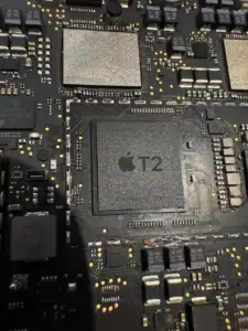 Mac 主機板上的 Apple T2 安全晶片 (Security Chip) 特寫：維修時辨識機型的重要依據，此晶片整合了 SMC、SSD 控制器與加密功能。