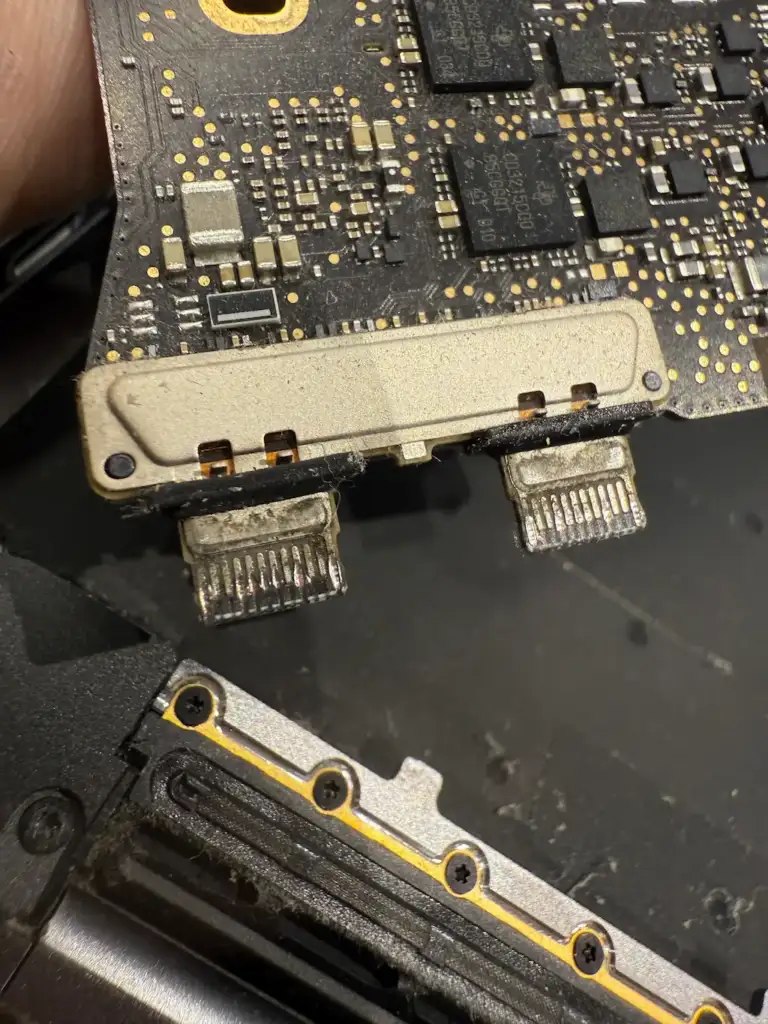 MacBook USB-C 接口特寫：說明外接 Type-C 集線器 (Hub) 產生的高溫如何經由金屬機身傳導至主機板，導致溫度感測器誤判並觸發風扇狂轉。