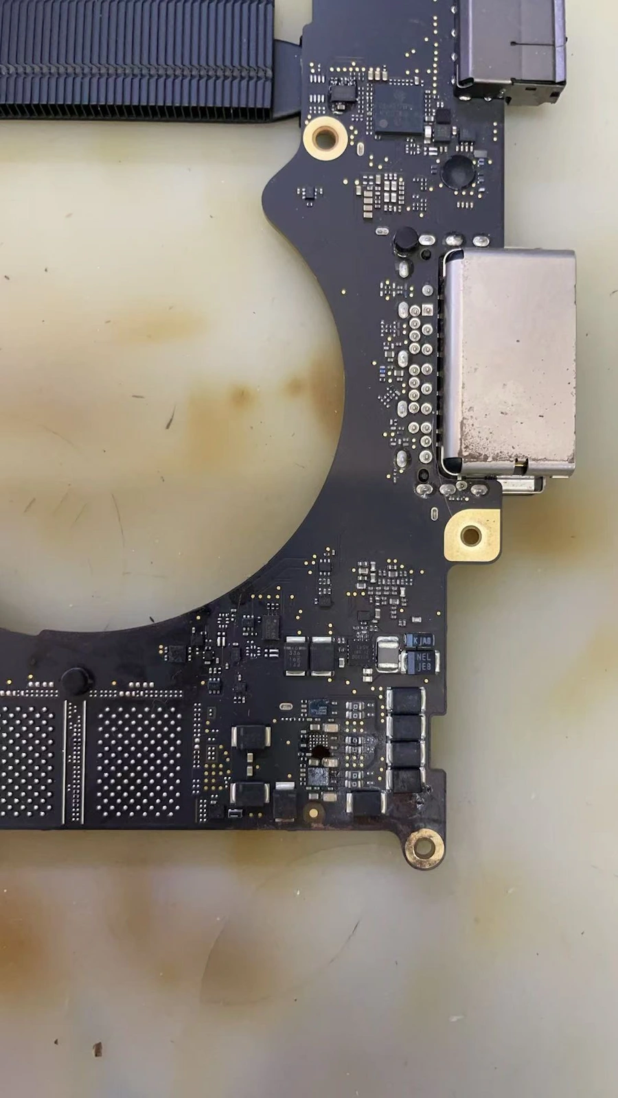 MacBook Pro A2442 PCB 板電路重建過程：顯微鏡下進行精密補接，重建硬碟主供電通路