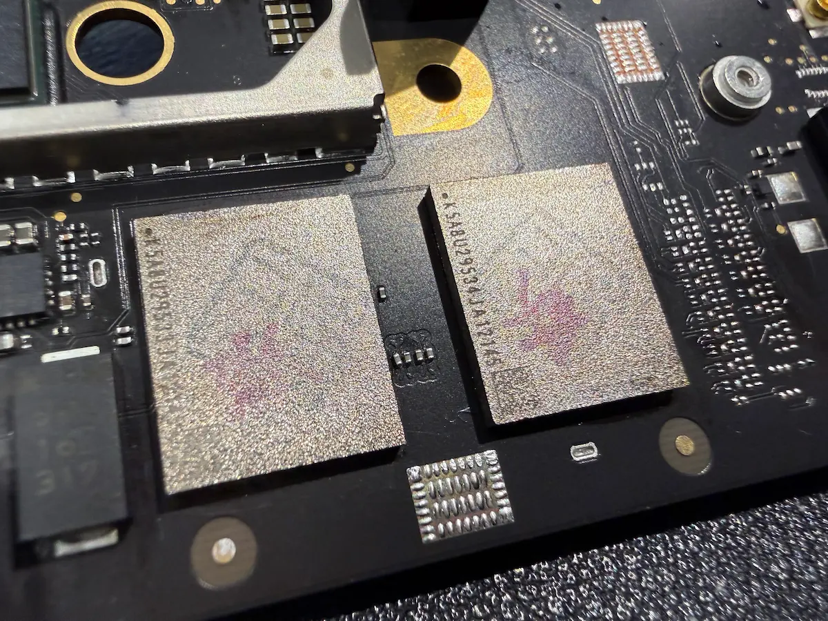 MacBook 主機板上直接焊死的 NAND Flash 快閃記憶體 BGA 顆粒微距特寫,展示 Apple M 系列無法自行擴充儲存容量的硬體設計