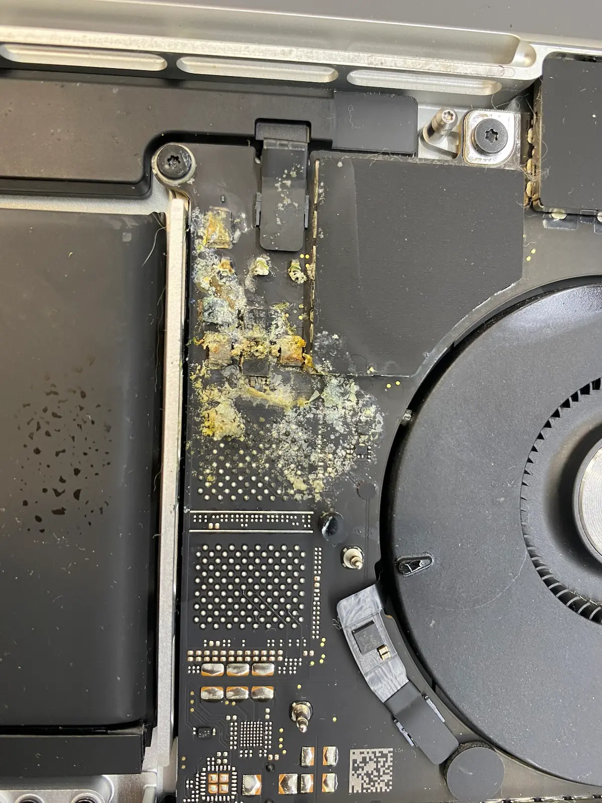 MacBook 進水 資料救援 案例:A2442 主機板湯汁嚴重腐蝕特寫,黃橙色殘留物與大範圍氧化鏽蝕覆蓋 PCB 板