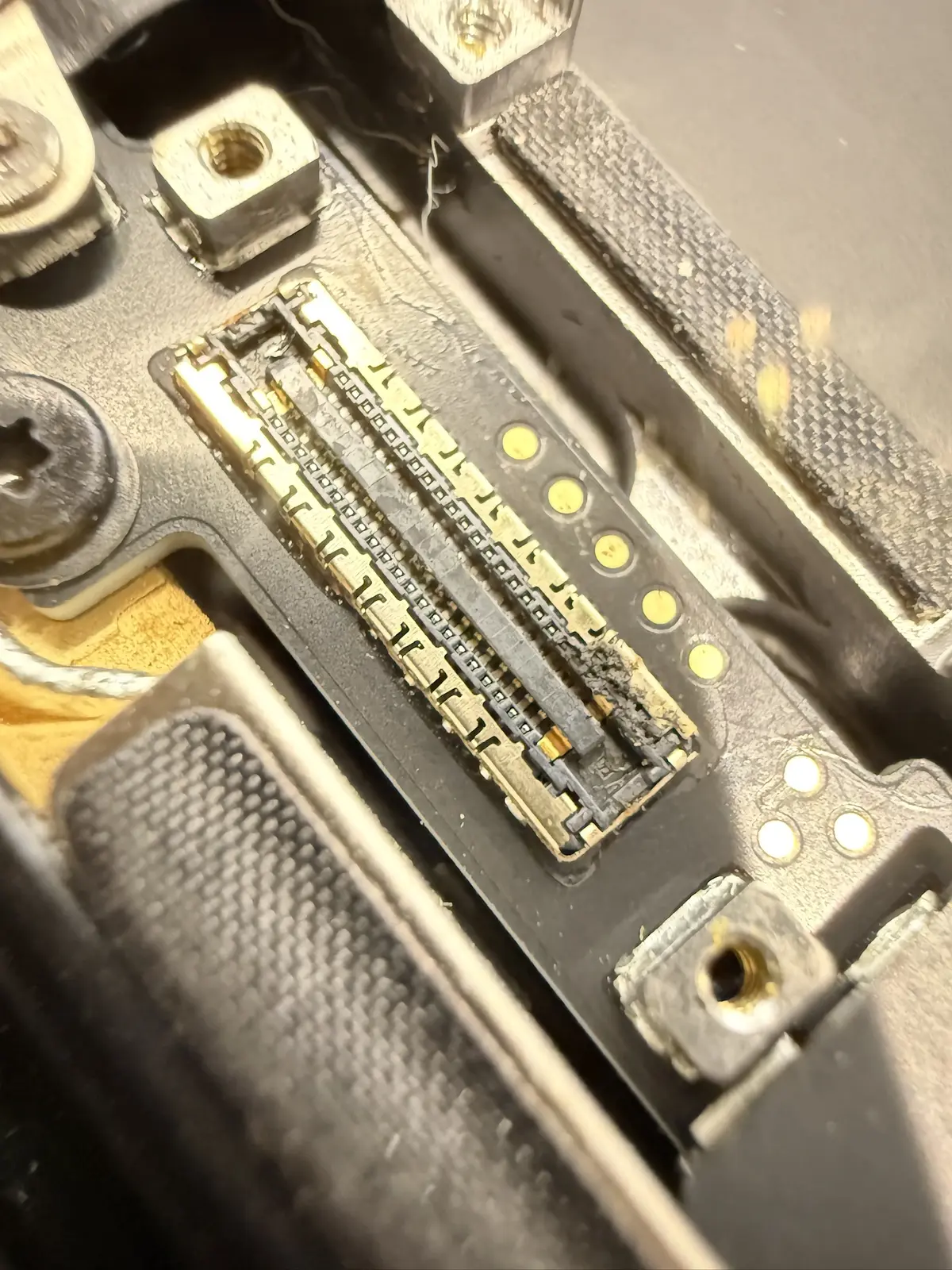 MacBook Pro 螢幕進水 案例的主機板連接座特寫，顯示受潮範圍