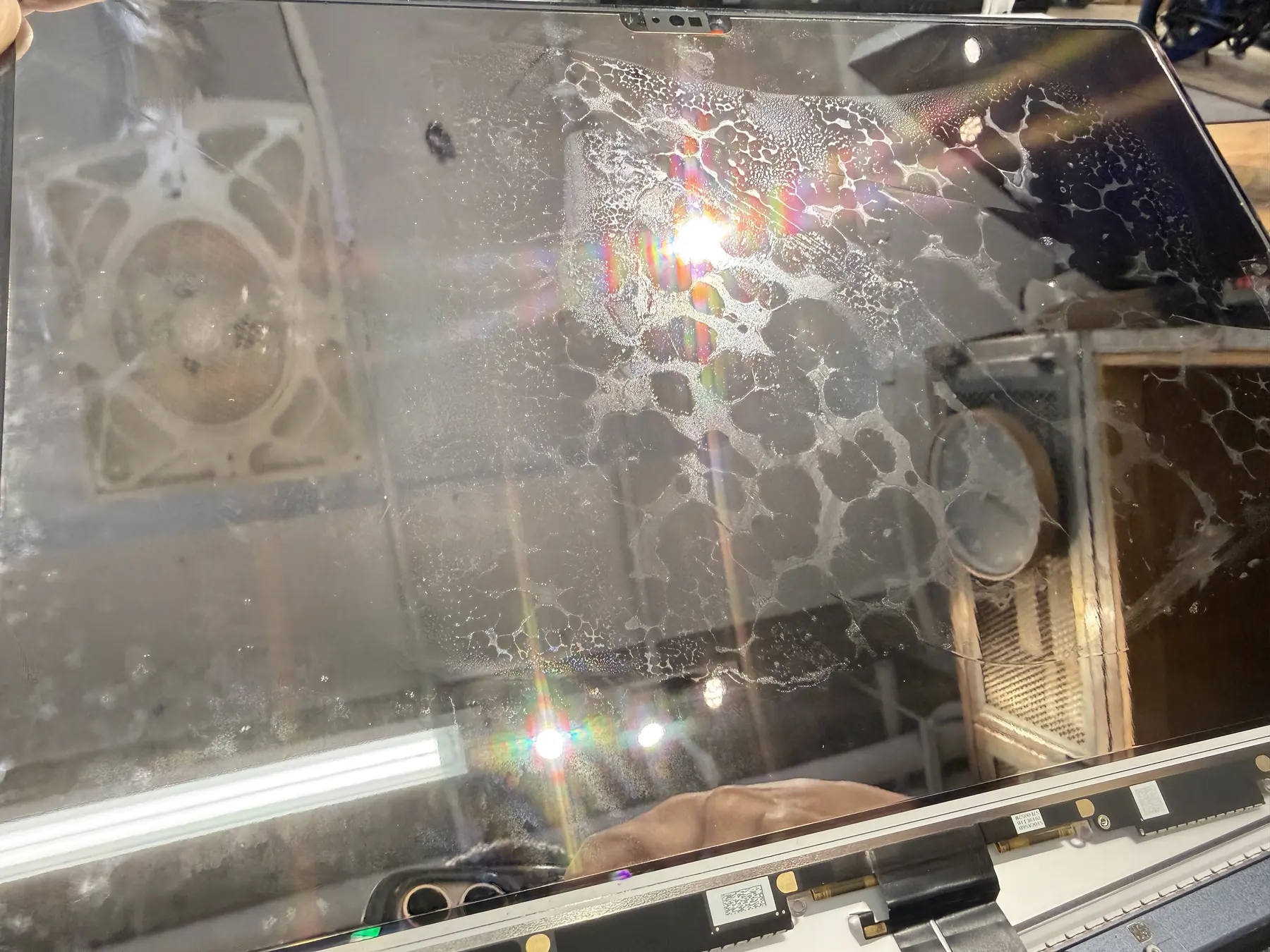  螢幕進水只要烘乾 迷思：液晶面板內部水痕特寫，水漬呈現蛛網狀分布在偏光層與玻璃之間